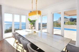 a dining room with a large white table and chairs at Villa Iva in Omiš