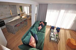 a living room with a green couch and a kitchen at Villa Iva in Omiš