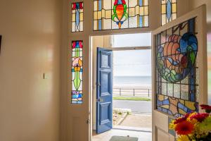 a hallway with stained glass doors with a view of the ocean at St Kitts Apartment in Filey