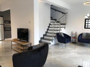 a living room with two chairs and a television at Luxurious 3-Bed Villa, Modern Decor, Communal Pool in Paphos