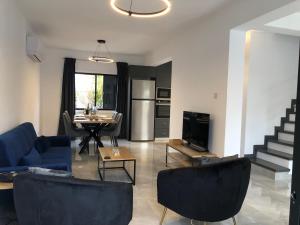 a living room with a blue couch and a table at Luxurious 3-Bed Villa, Modern Decor, Communal Pool in Paphos +34 photos