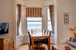 a dining room with a table and chairs and a window at St Kitts Apartment in Filey