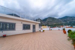 un edificio con una terraza con montañas en el fondo en Dar bensaid, en Chefchaouen