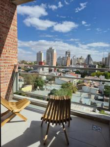 a balcony with a bench and a view of a city at Beautiful brand new apartment in Neuquén