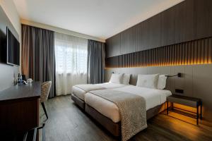 a hotel room with a large bed and a desk at HF Ipanema Porto in Porto