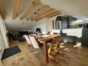 a kitchen and dining room with a wooden table and chairs at Connys FeWo Berg in Großengstingen