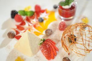 a plate of food with cheese and fruit on it at Sonnenhof Resort Himmelreich Bayerischer Wald in Lam +113 photos