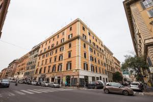 um grande edifício numa rua da cidade com carros estacionados em Sweet Stay In Rome em Roma