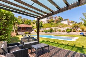 a patio with a table and chairs and a swimming pool at Bungalow Chalé da Caniçada in Rio Caldo