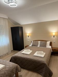 a hotel room with two beds with towels on them at Vila Gracija in Arandelovac +37 photos