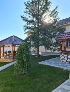 a garden with a tree and a gazebo at Vila Gracija in Arandelovac