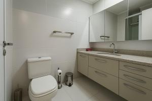 a white bathroom with a toilet and a sink at Aᴘᴀʀᴛᴀᴍᴇɴᴛo404, ᴄᴏᴍᴘʟᴇᴛᴏ ᴄᴏᴍ ᴇsᴛᴀᴄɪᴏɴᴀᴍᴇɴᴛᴏ, Wɪ-Fɪ, Gʏᴍ, Tᴠ Sᴍᴀʀᴛ, Cᴏᴡᴏʀᴋɪɴɢ - ᴘᴀʀᴀ ᴀᴛé ᴅᴜᴀs ᴘᴇssᴏᴀs in Sao Paulo +30 photos
