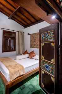 une chambre avec un lit et une armoire avec des vitraux dans l'établissement Vintage room 2 in Joglo House By penggemarlawas, à Kamparganya