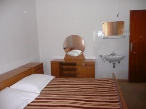 a bedroom with a bed and a sink and a mirror at Apartment in Rab/Insel Rab 16488 in Mundanije