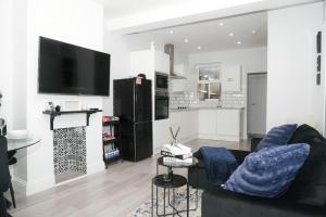 a living room with a couch and a tv on a wall at Luxury 3-Bedroom Home , with Free parking in Dartford