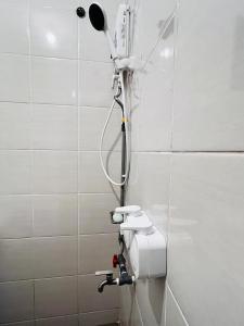 une douche dans une salle de bain avec un sèche-cheveux au mur dans l'établissement AGORA HOMESTAY Kota Marudu, à Kampong Karungkon