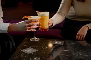 two people are holding drinks on a table at HF Ipanema Porto in Porto +19 photos