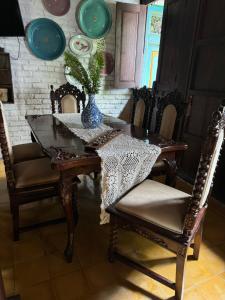 une table à manger et des chaises avec un vase au-dessus dans l'établissement Vintage room 2 in Joglo House By penggemarlawas, à Kamparganya 19 autres photos