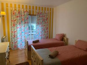 Un dormitorio con dos camas y una ventana. en Ocean views - 270 degrees, en Ericeira