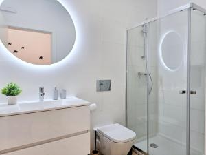 a bathroom with a toilet and a sink and a mirror at CASINHA DE LAGOA - Cozy House, AC & Wi-Fi in Lagoa