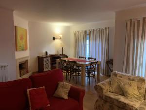 Una sala de estar con un sofá, una mesa y sillas. en Ocean views - 270 degrees, en Ericeira