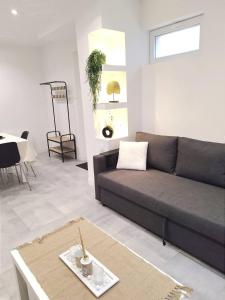 a living room with a couch and a table at La petite maison in Therdonne +1 photo