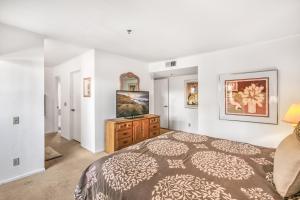 a bedroom with a bed and a flat screen tv at Deauville Comfort in Downtown PS in Palm Springs