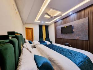 a hotel room with beds and a flat screen tv at Hotel Summer Palace Murree in Murree