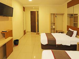 Ein Bett oder Betten in einem Zimmer der Unterkunft Super OYO Townhouse OAK Hotel Fiducia Serpong