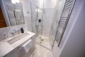 a bathroom with a sink and a glass shower at Rainforest Studio Downtown by Pretty Apartments in Bucharest