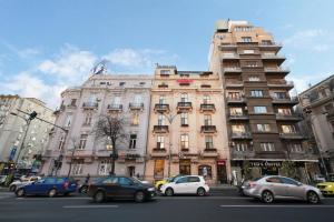 a large building with cars parked in front of it at Rainforest Studio Downtown by Pretty Apartments in Bucharest
