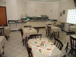 een eetkamer met tafels en stoelen met gebak erop bij Villa Verde Hotel in Naviraí