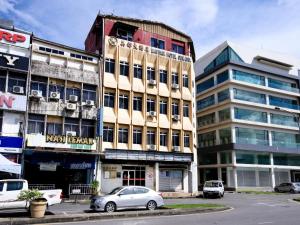 a tall building with cars parked in front of it at Hotel O Mayfair Hotel in Kuching
