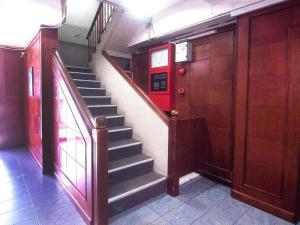a staircase in a building with a red door at Hotel O Mayfair Hotel in Kuching