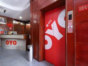 a restaurant with a red door with a sign on it at Hotel O Mayfair Hotel in Kuching