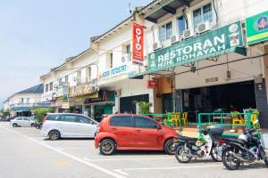 タンジュン・マリムにあるOYO 1224 Hotel Hajah Rohayahの赤車・二輪車