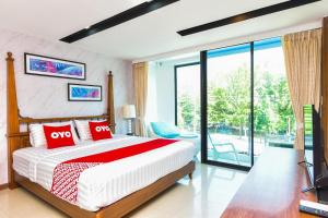 a bedroom with a large bed and a balcony at OYO 394 Nana Beach Cha Am in Cha Am