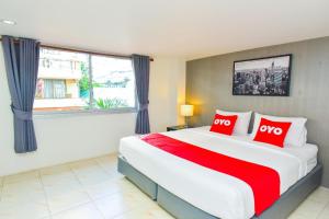 a bedroom with a large bed with red pillows at OYO 394 Nana Beach Cha Am in Cha Am +31 photos