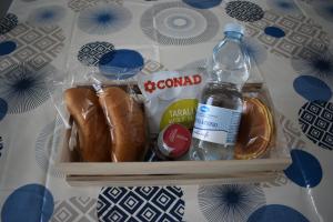 a container filled with hot dogs and a bottle of water at Casina al mare in Cecina