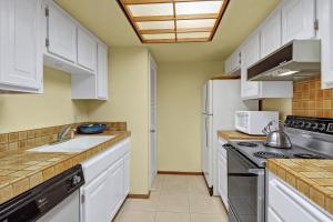 a kitchen with white cabinets and a sink at 2BR Plaza Villas Bungalow Deluxe by Oranj Palm in Palm Springs +23 photos