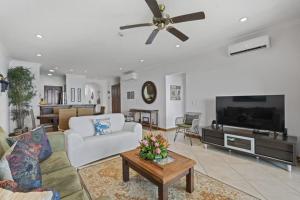 a living room with a couch and a ceiling fan at Stunning Condo with Panoramic Beach, Ocean, and Mountain Views in Playa Flamingo in Playa Flamingo