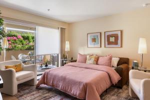 a bedroom with a bed and a chair and a window at 1BR Plaza Villas Bliss - Downtown PS in Palm Springs +16 photos