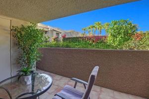 a patio with a glass table and chairs on a balcony at Plaza Villas Posada by Oranj Palm in Palm Springs