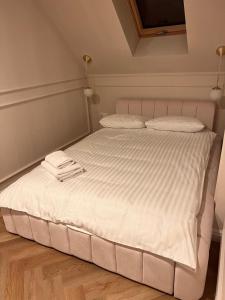a white bed with two towels on top of it at Kameralna Domki in Bystrzyca Nowa +1 photo