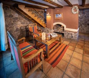a living room with a table and chairs and a fireplace at Sacred Dreams Lodge in Urubamba
