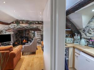 Eine Küche und ein Wohnzimmer mit einem Steinkamin in der Unterkunft Top Cottage Barmouth in Barmouth