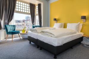 a bedroom with a large bed and a yellow wall at Villahotel Vlissingen in Vlissingen