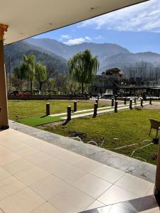 Jharoka Resort - Taranna, Balakot في Hassa: اطلالة على حديقة فيها جبال في الخلفية
