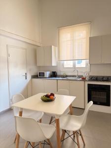 a kitchen with a table and chairs with a bowl of fruit on it at Olive A Heritage 2Bedroom Apartment in Mar Mikhael in Beirut