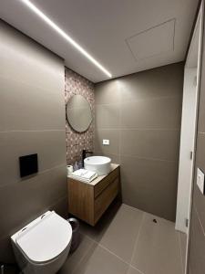 a bathroom with a toilet and a sink and a mirror at Sol, 1BR Gemmayze in Beirut